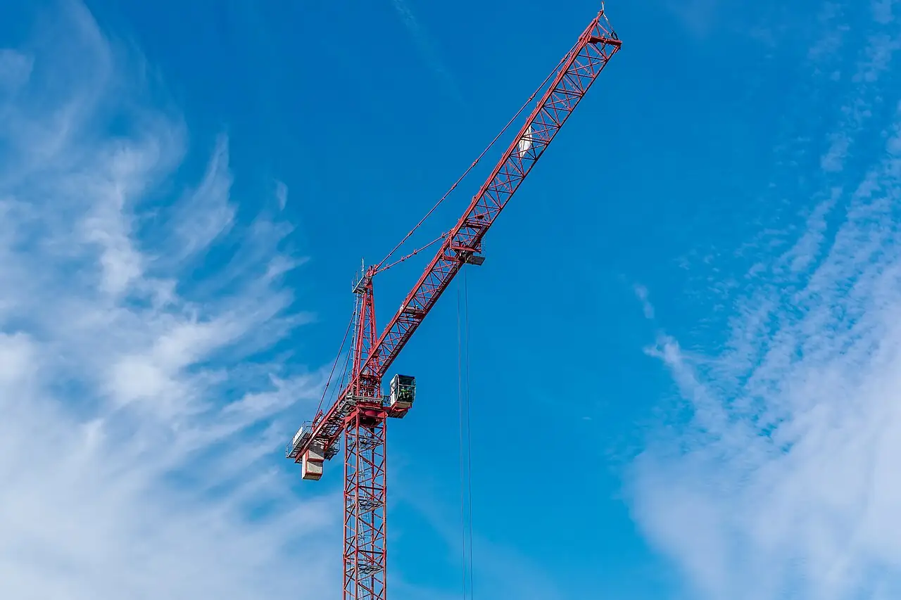 Red tower crane against a blue sky
